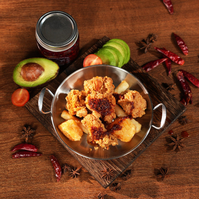 Fried chicken with pineapple on a wooden board with spices and fruit