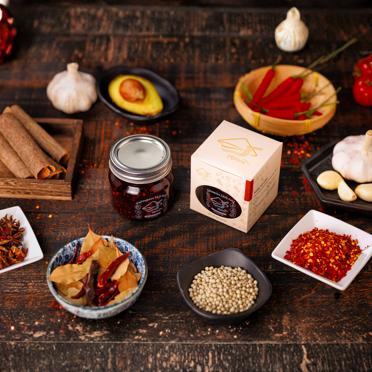 Spices and ingredients on a wooden surface with a box of spices in the center.